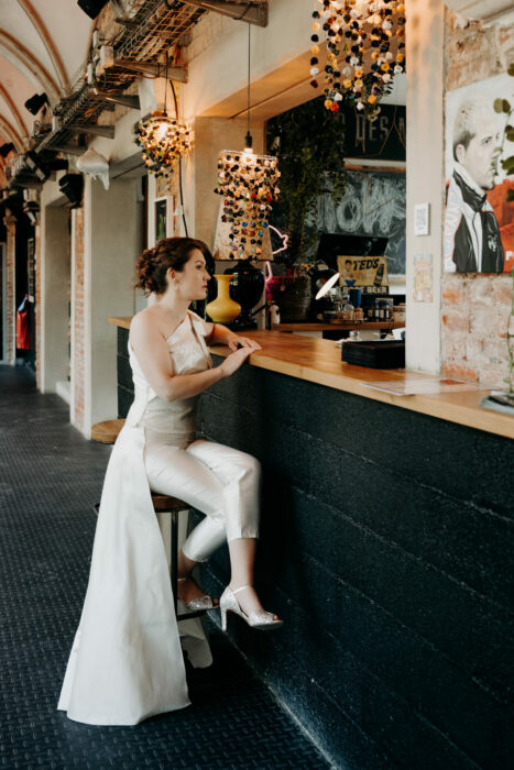 Tenue de mariée en soie avec un pantalon, un top asymétrique et une traîne amovible