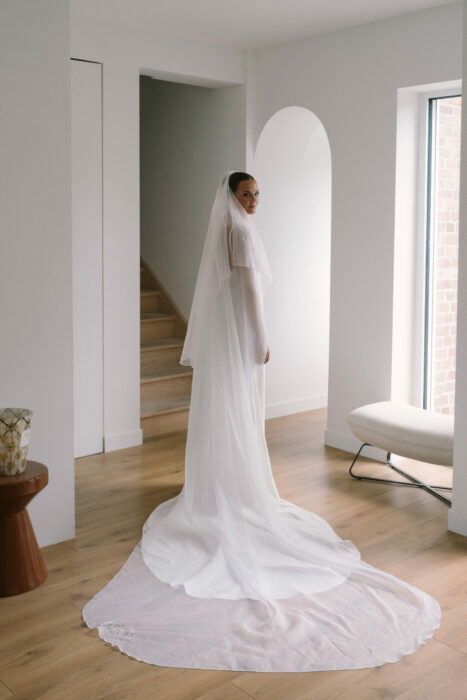 Mariée avec voile de mariée en organza de soie brodé. Le voile est brodé des initiales des mariés.