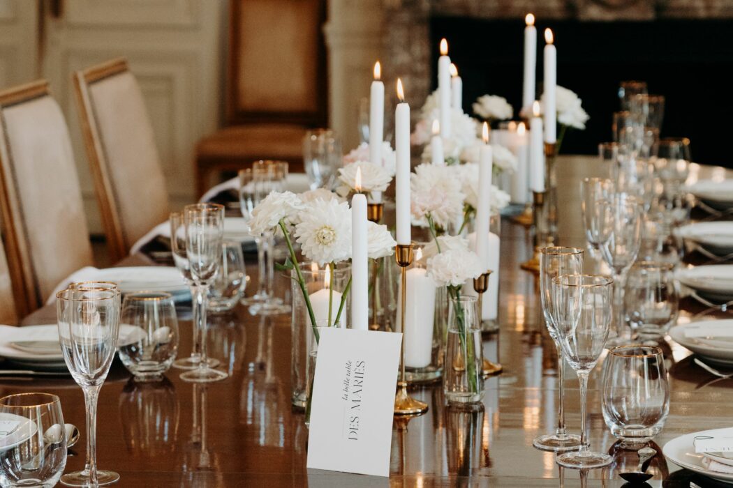 Décoration d'une table des mariées avec une table en bois, des bougies et fleurs de saison